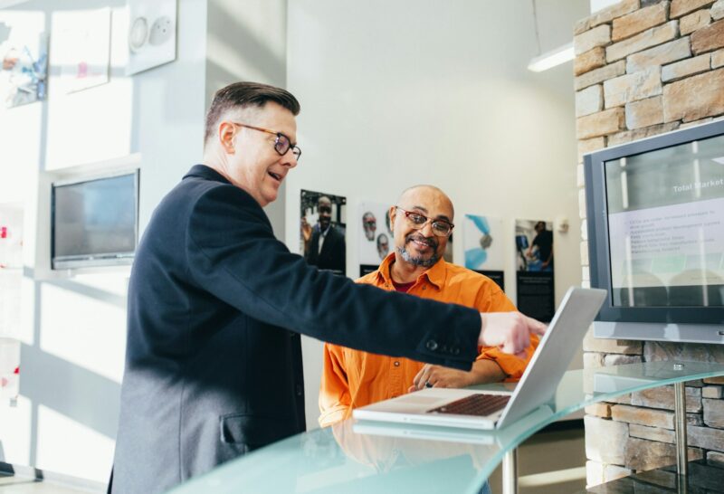 Friendly technician showing a client results on a laptop