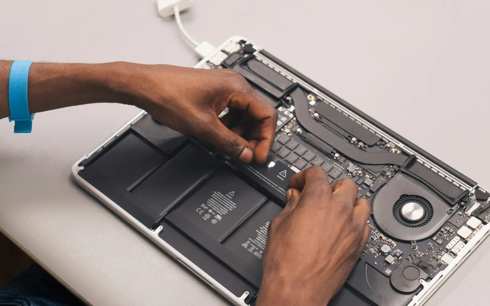 Technician repairing a laptop at a client's desk